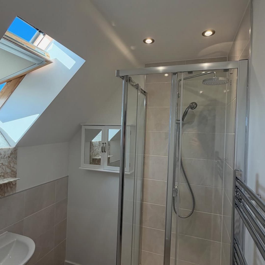 Loft conversion en-suite shower room with freshly painted walls and skylight