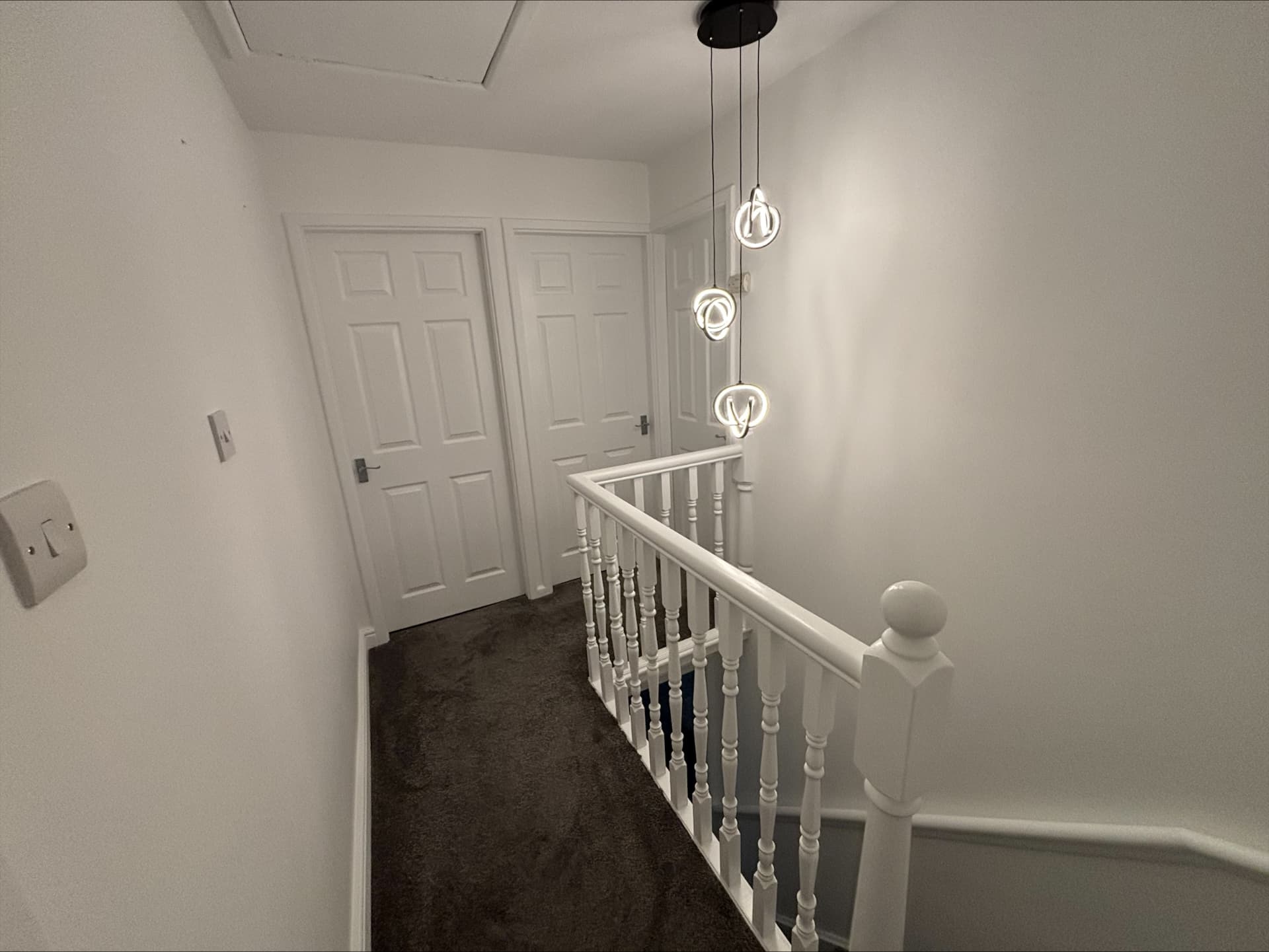 Freshly painted brilliant white landing with hand-painted turned spindles, handrail and panelled doors