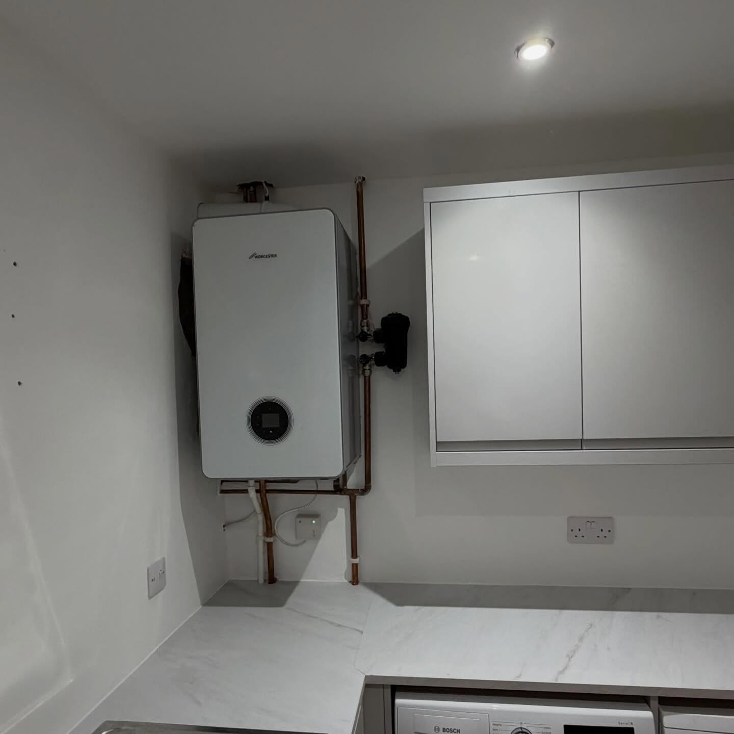 Utility area and boiler cupboard finished with crisp white walls and units