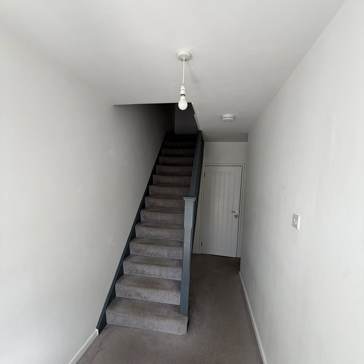 Bright repainted hall and staircase with fresh white walls and woodwork