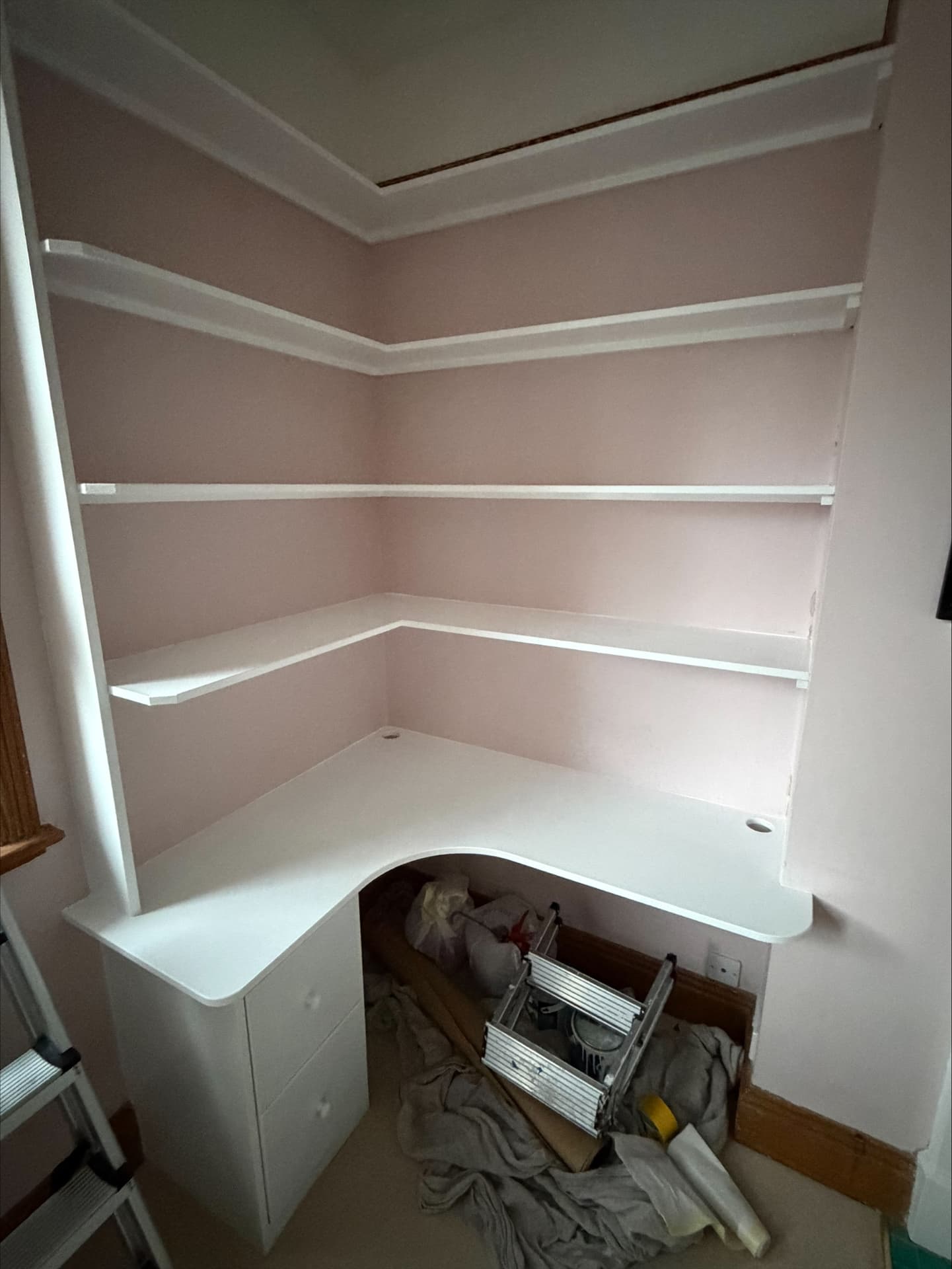 Blush pink alcove study with hand-painted white fitted shelving, desk and drawer unit