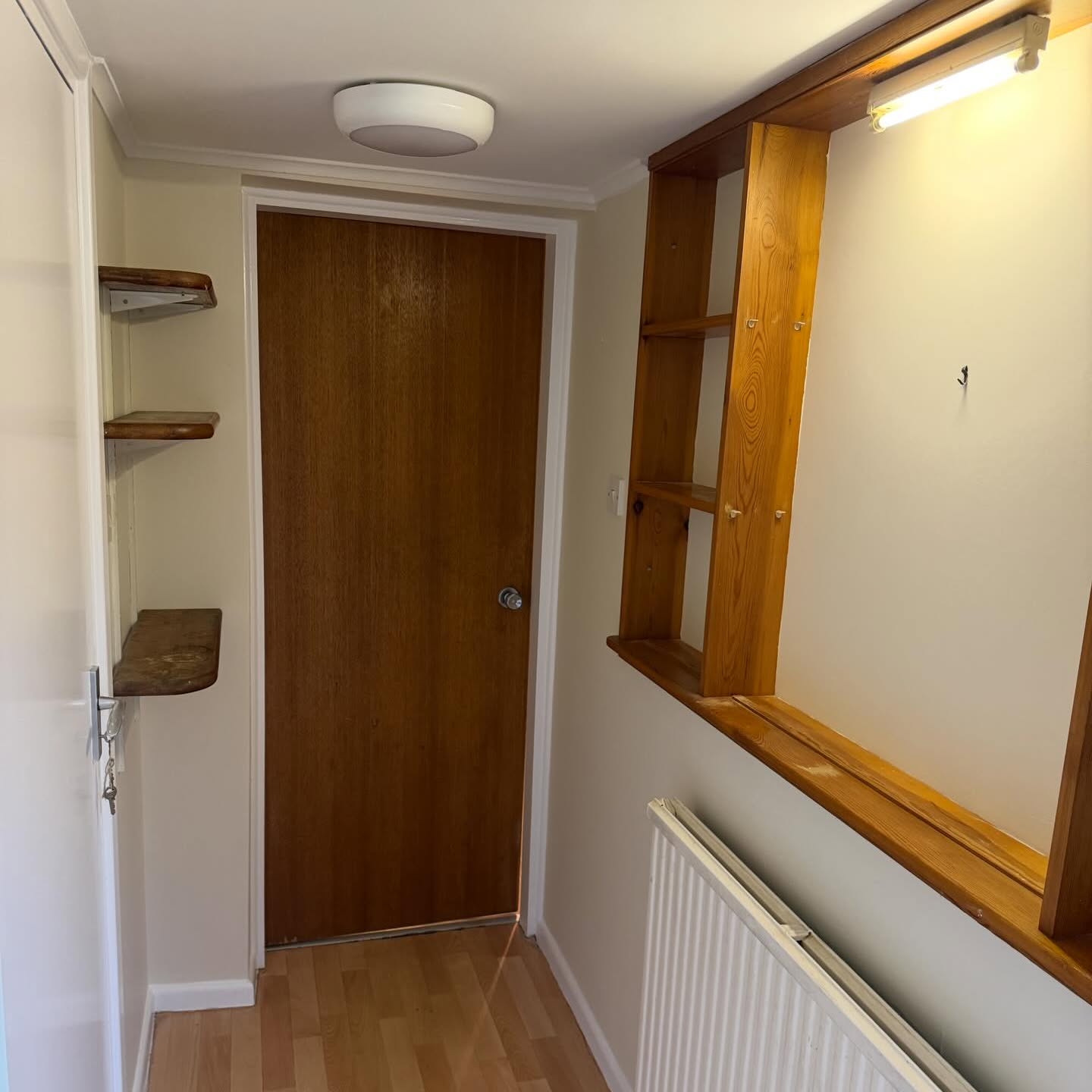 Landing with freshly painted walls, original oak doors and timber shelving