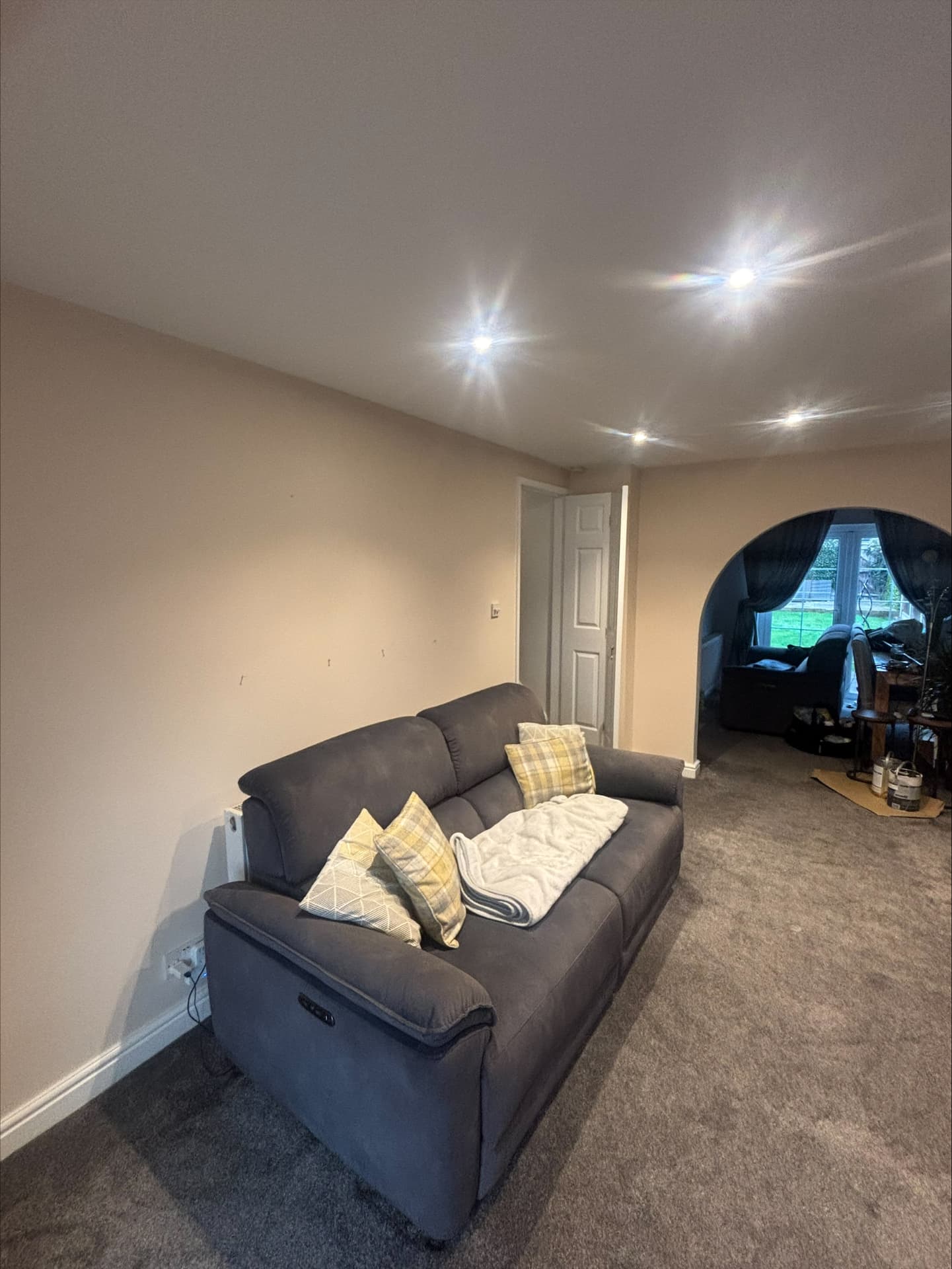 Through-lounge painted in warm stone with a curved archway and white skirtings