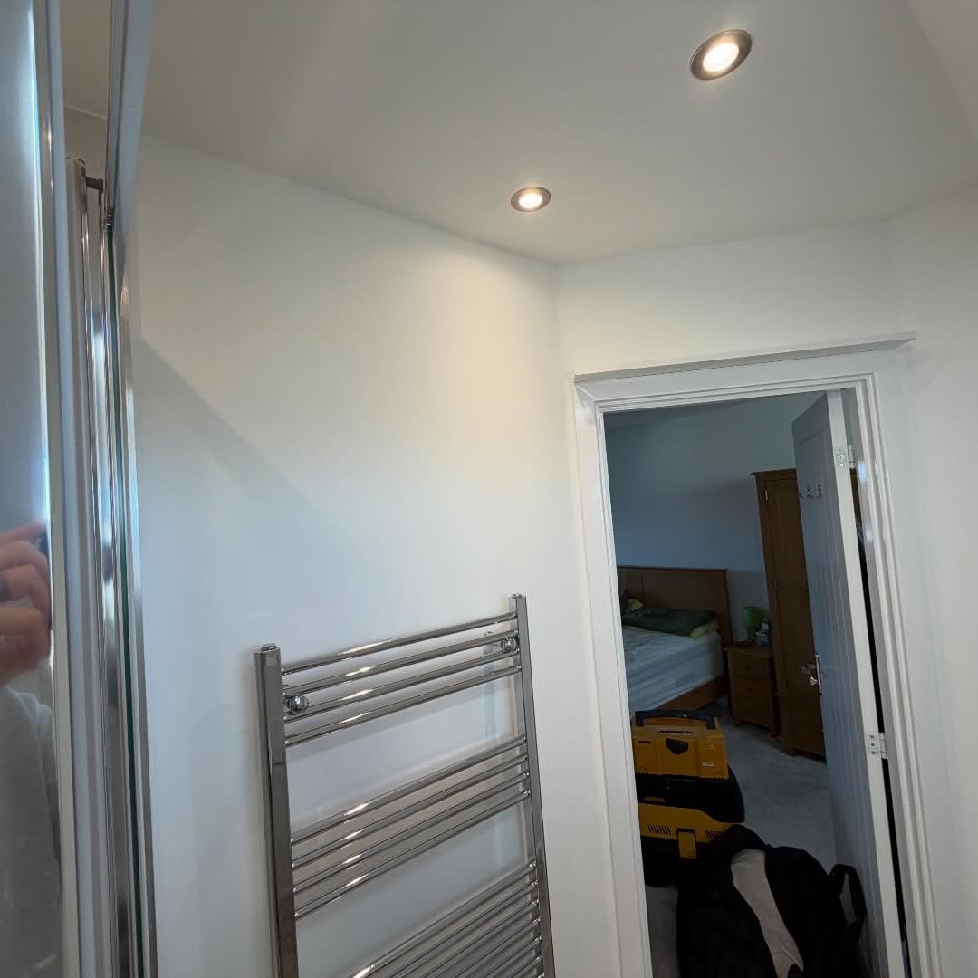 Loft shower room and landing with chrome towel rail and fresh white walls