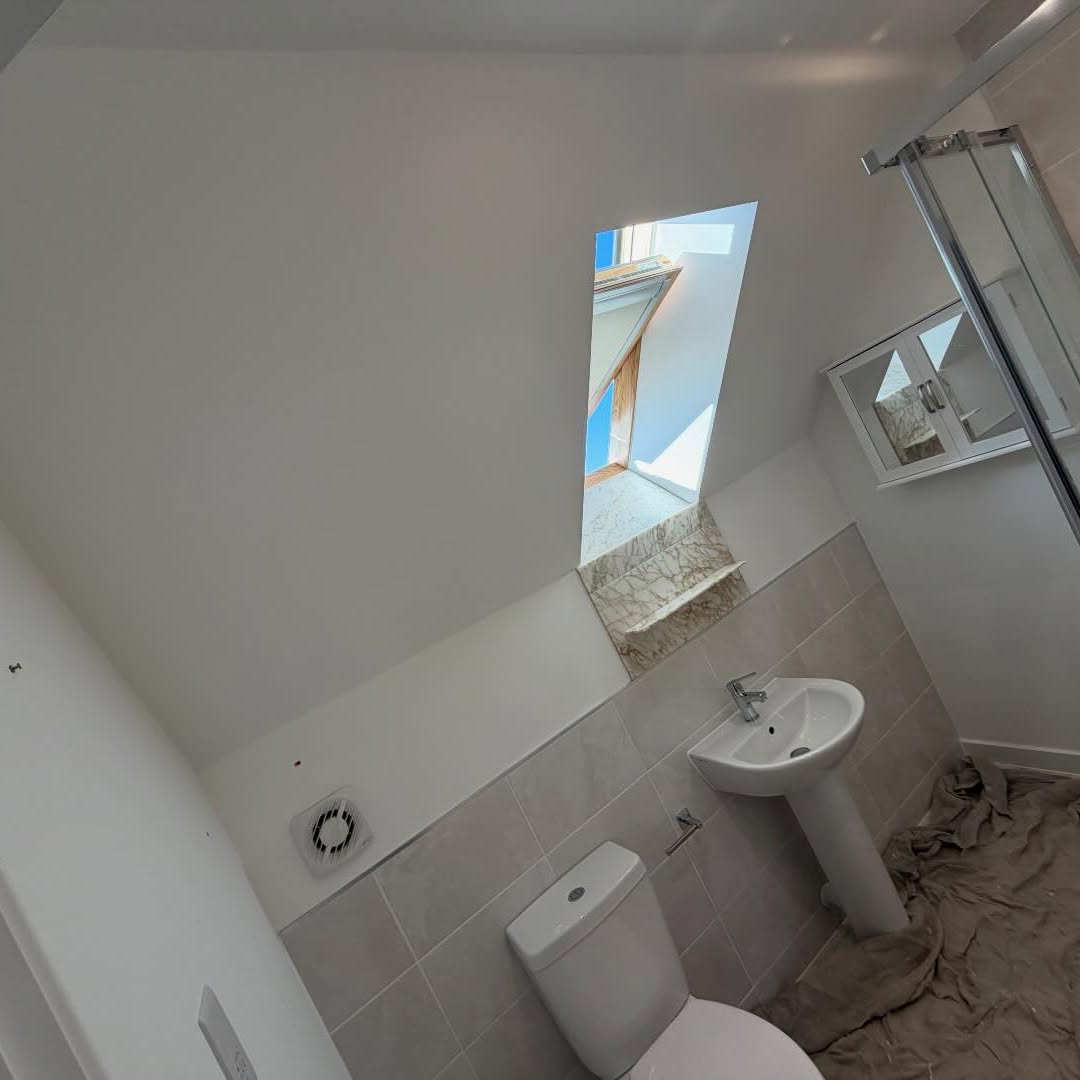 Loft bathroom mid-decoration with freshly painted sloped ceilings
