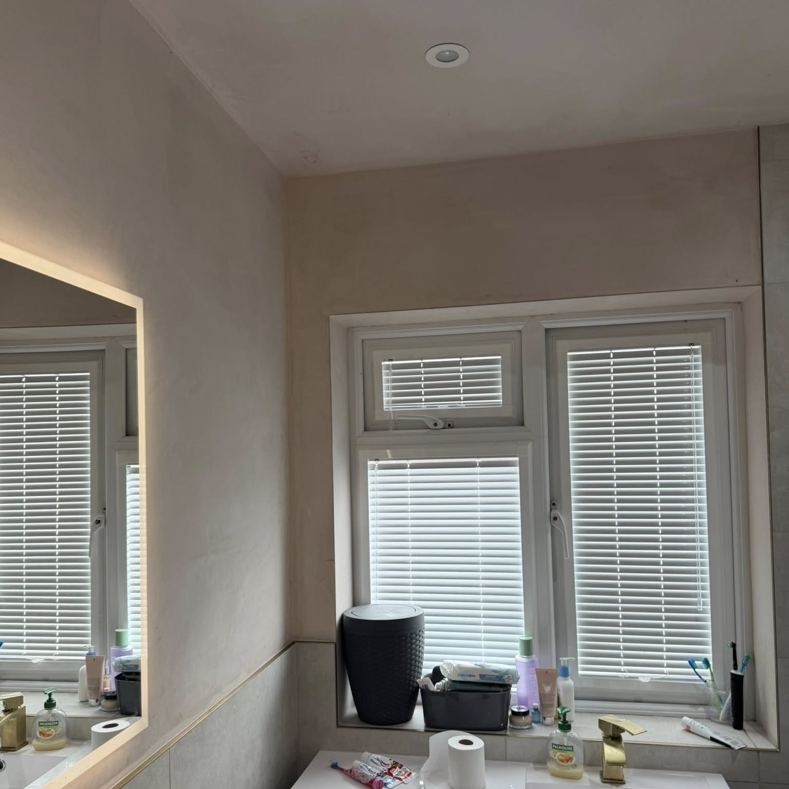 Bedroom freshly decorated in warm neutral tones with white shutters