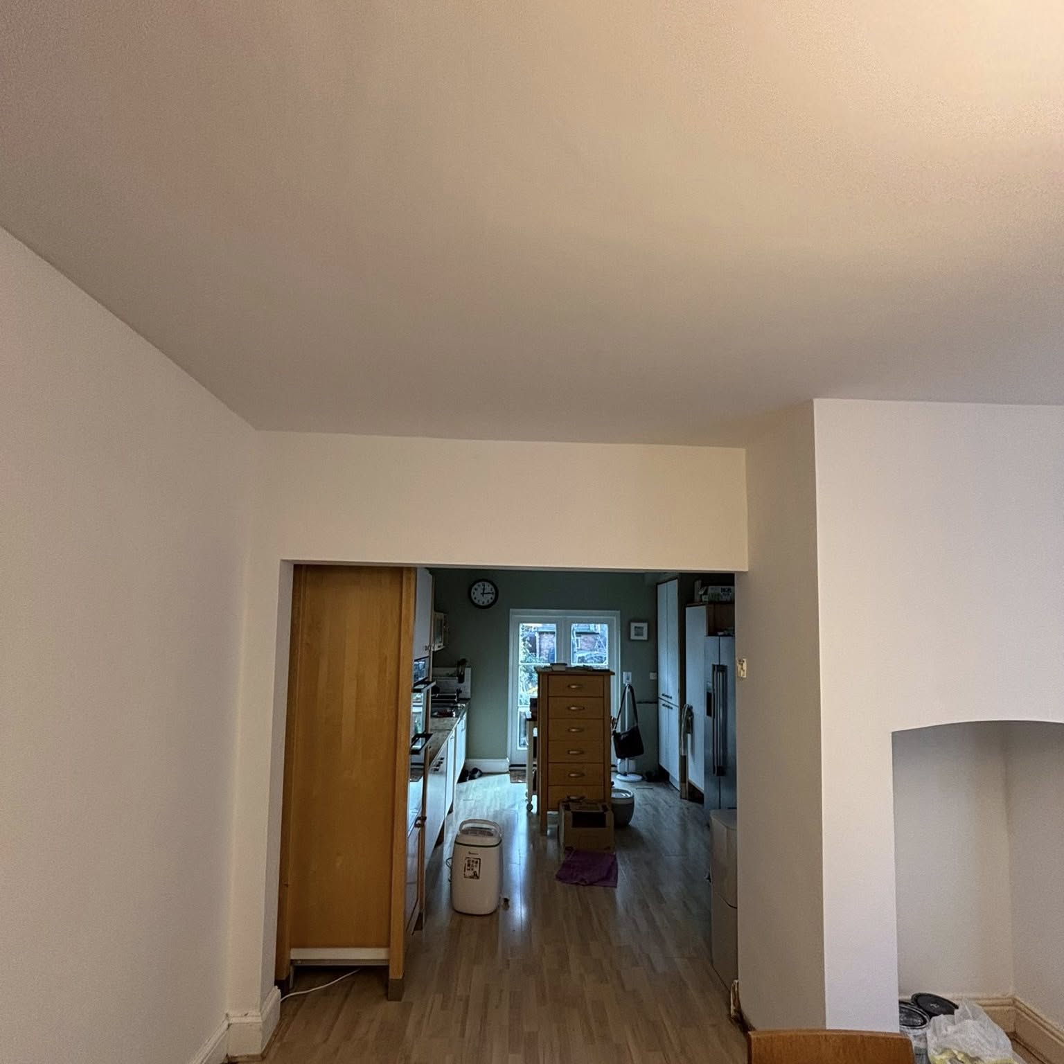 Light, freshly painted hallway looking through to a living space beyond