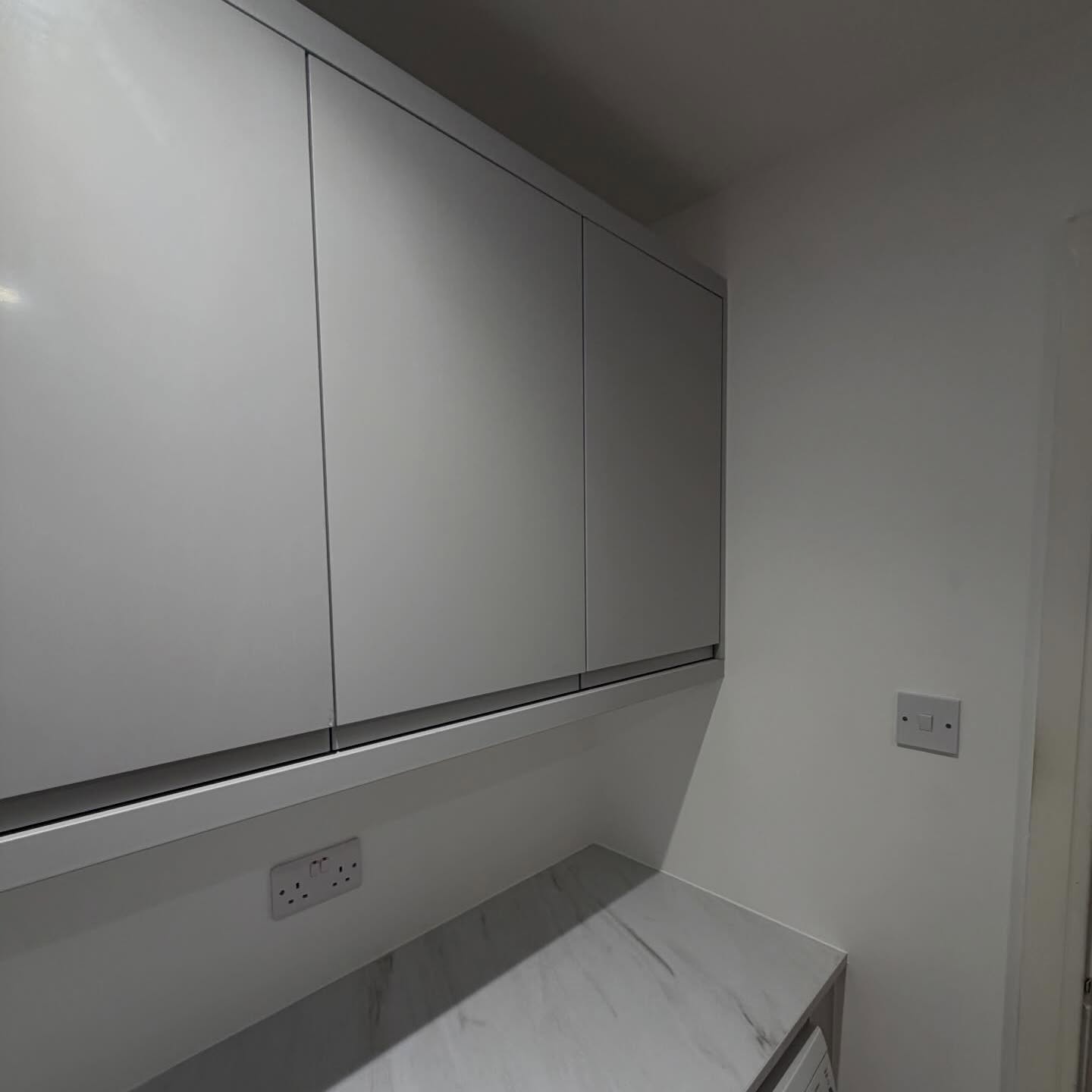 Fitted wardrobe cupboards finished in smooth grey with marble-effect surface