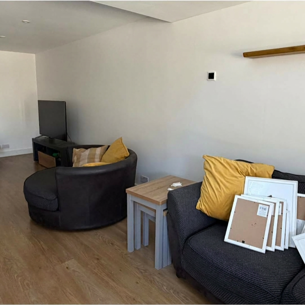 Open-plan living room with freshly painted white walls and ceiling