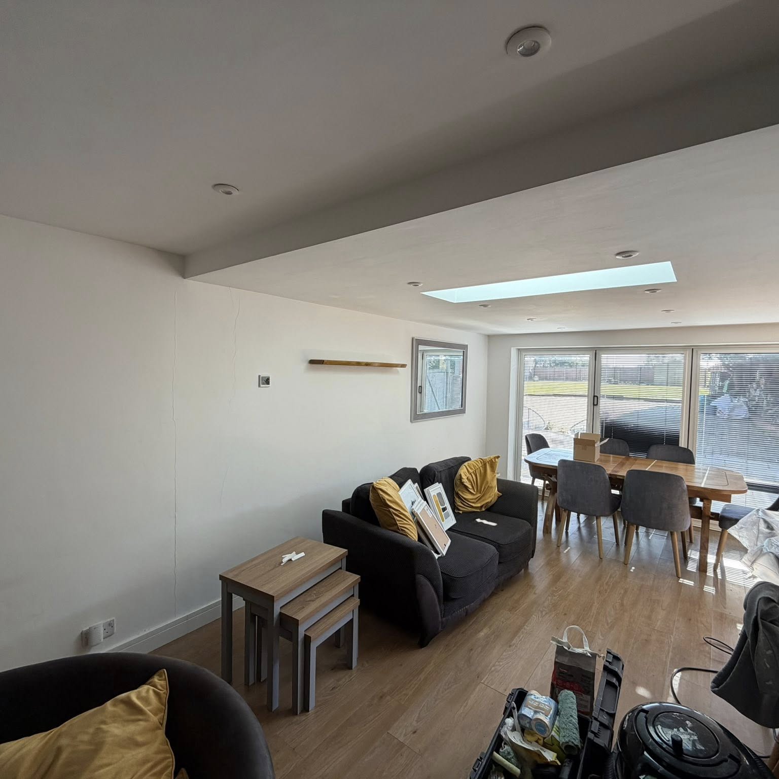 Light-filled open-plan living space with skylight and freshly decorated walls