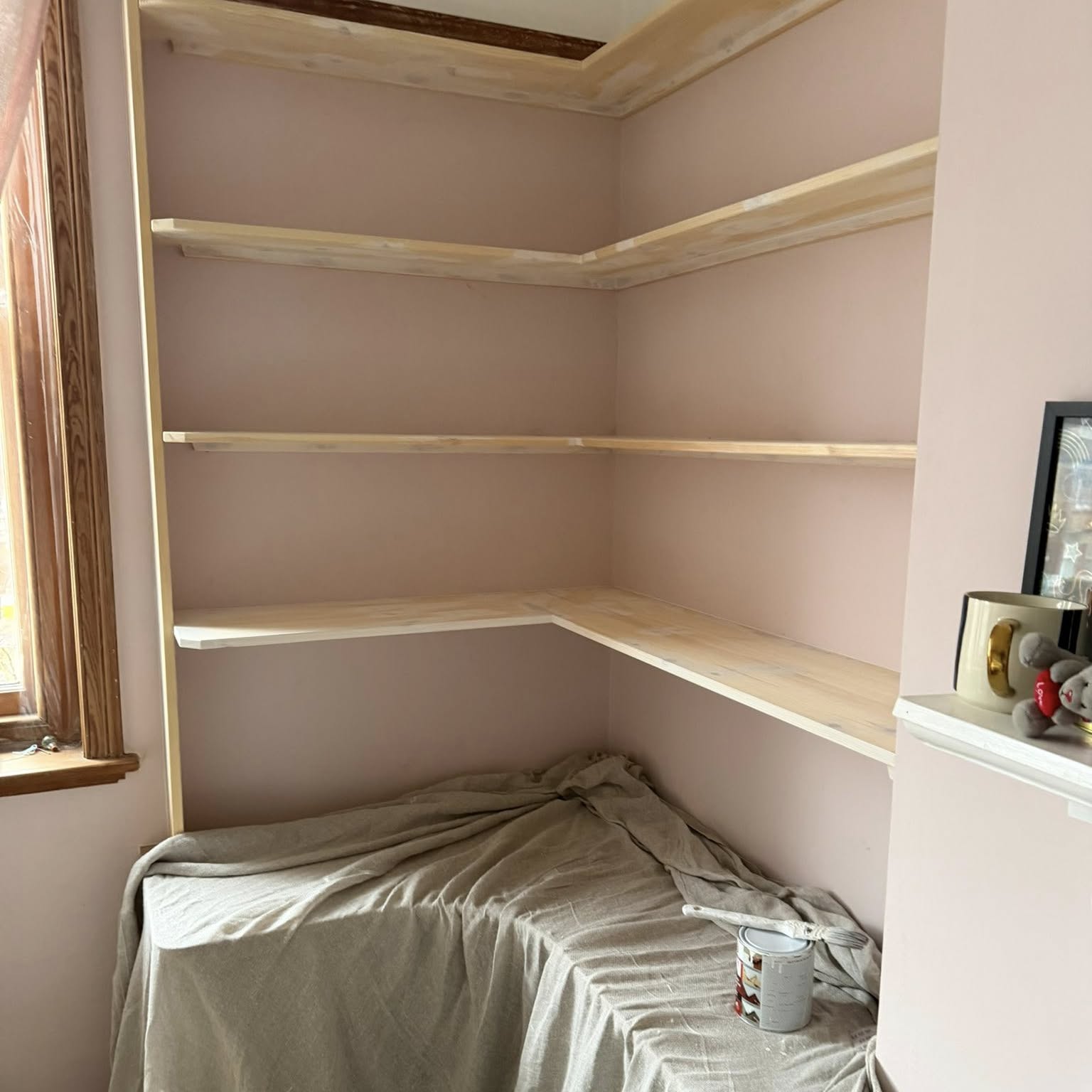 Built-in alcove shelving painted in a soft pink scheme
