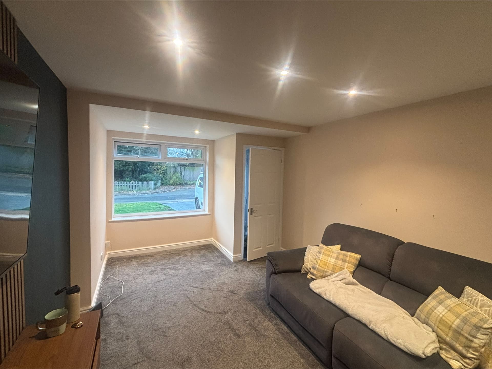 Freshly decorated lounge in warm neutrals with a deep teal painted chimney breast