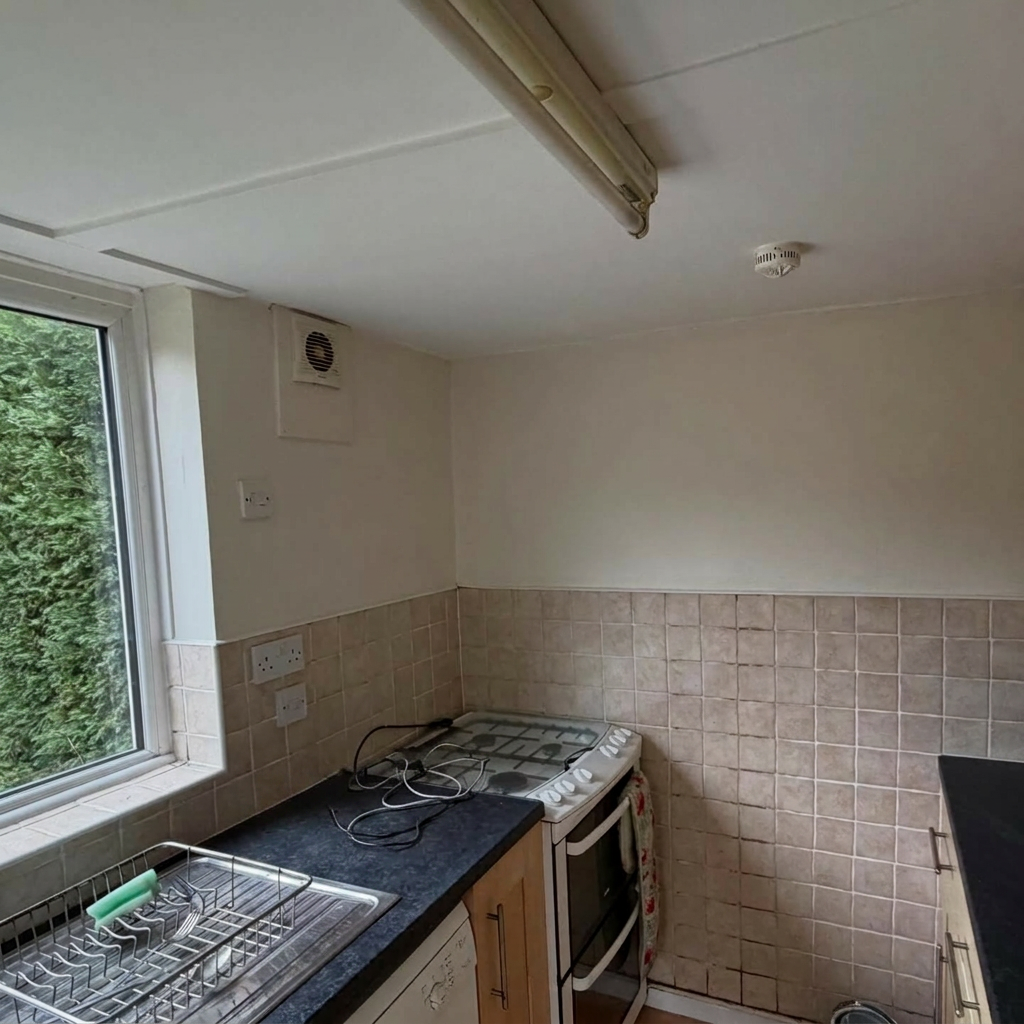 End-of-tenancy kitchen with walls and ceiling freshly repainted in clean white