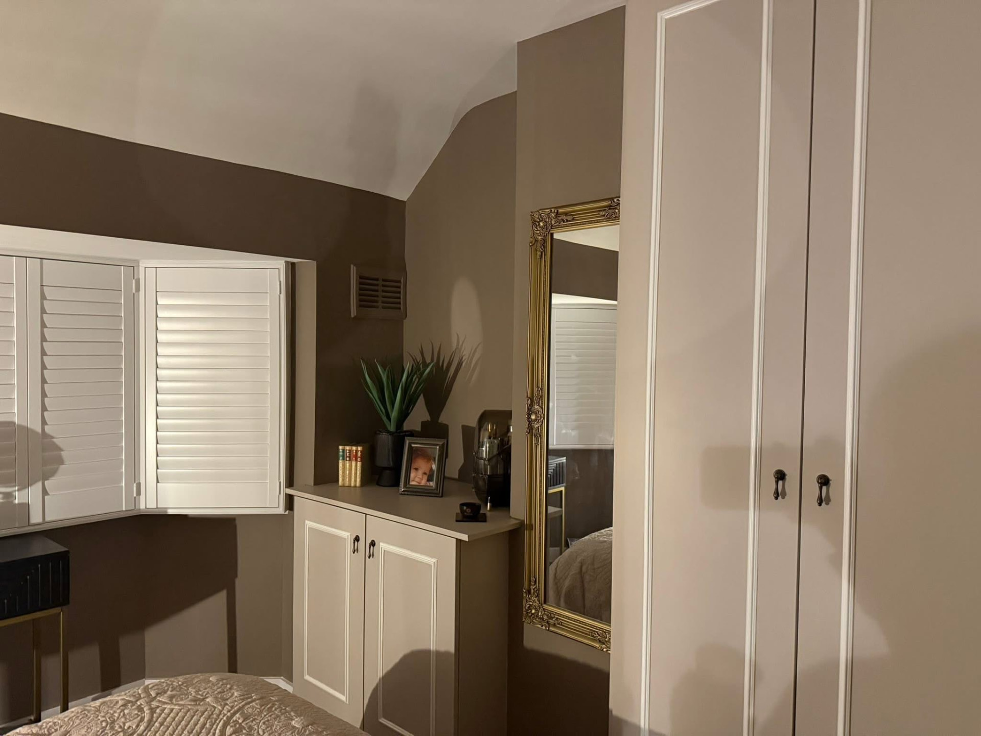 Hand-painted bedroom cupboards and dresser in mushroom against taupe walls with white shutters