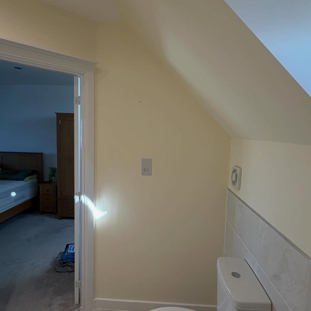 Loft conversion bedroom with sloped ceilings freshly painted in soft white
